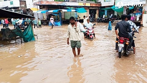 Villagers walking through knee-deep water in the main square of the village.