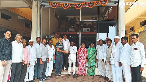 Entrepreneur Parag Pawar and villagers giving cash to the farmer.