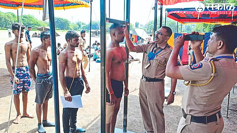 A policeman measuring the height of candidates during a physical test at the police drill ground on Sunday as part of the Home Guard recruitment process
