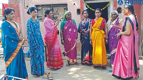 Government employees interacting with women voters regarding voting awareness in rural areas.