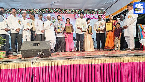 Anna Hazare felicitating social workers during an award ceremony at Ralegan Siddhi, praising their dedication to community service.