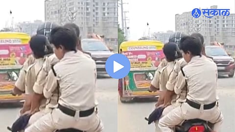 Four policemen riding on a single motorcycle without proper safety measures, violating traffic rules as captured in a viral video.