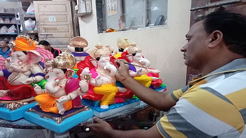 गणेशमूर्तीवर रंगकाम करताना