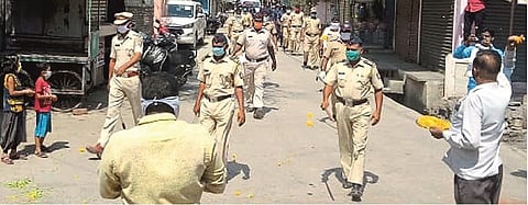 कळंब : पथसंचलन करणाऱ्या पोलिसांवर शहरातील देवीरोड भागात फुलांची उधळण करताना नागरिक.