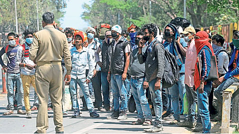प्रयागराज (उत्तर प्रदेश) - लॉकडाउनमुळे बाहेर गावांहून आलेल्या स्थलांतरित कामगारांकडे चौकशी करताना पोलिस.