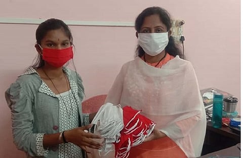 कळंब : गरजूंना वाटप करण्यासाठी तयार केलेले शंभर मास्क नायब तहसीलदार परवीन पठाण यांच्याकडे देताना वैष्णवी मोरे.