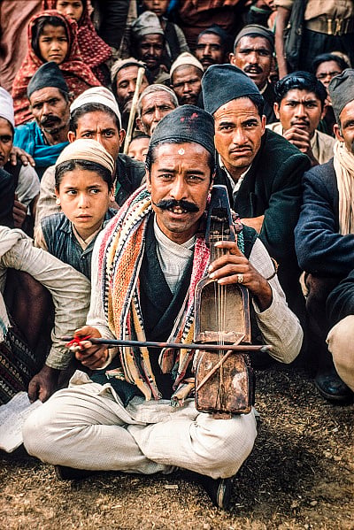 Gulmi, 1966. At the peak of the Panchayat period, this man sings songs about national glory: "Hamro Tenzing Sherpale Chadhyo Himal Chuchura" (Our Tenzing Sherpa has climbed to the top of the Himalaya). Gaines like him traveled from village to village singing songs about contemporary events.
Photo: Carl Hosticka / Nepal Picture Library