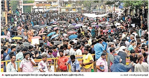 மதுரை தமுக்கம் மைதானத்தில் கொட்டும் மழையிலும் குடை பிடித்தபடி போராட்டம்