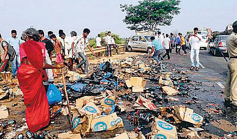 கர்நாடகாவில் விபத்தில் கவிழ்ந்த லாரியிலிருந்து சிதறிய பீர் பாட்டீல்களை அள்ளிச் சென்ற பொதுமக்கள்