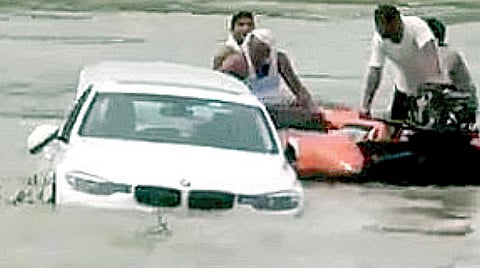 ஆற்றில் தள்ளிய சொகுசு காரை மீட்கும் நீச்சல் நிபுணர்கள்.