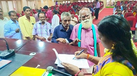 மாவட்ட வருவாய் அலுவலர் சி.முத்துமாரியிடம் மனு வழங்கும் முதியவர். (பச்சை துண்டு அணிந்திருப்பவர்)