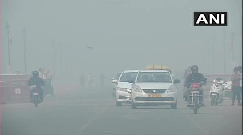 டெல்லி இந்தியா கேட் பகுதியில் காற்றின் மாசுக்கு நடுவே வாகனங்களை இயக்கிவரும் வாகன ஓட்டிகள் : படம் ஏஎன்ஐ