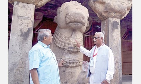 தஞ்சாவூர் பெரிய கோயிலில் மாமன்னன் ராஜராஜ சோழனால் நிறுவப்பட்ட நந்தி சிலையின் சிறப்புகள் குறித்து தனது நண்பருக்கு விளக்கமளிக்கிறார் பெரிய கோயில் குடமுழுக்கு விழா உயர்மட்டக் குழு உறுப்பினரும் தஞ்சாவூர் மாவட்ட முன்னாள் ஆட்சியருமான டி.கங்கப்பா (வலது). படம்: வி.சுந்தர்ராஜ்