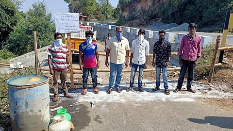 கொடைக்கானல் அருகே பேத்துப்பாறை மலை கிராமத்திற்கு நுழையும் சாலையில் தடுப்பு ஏற்படுத்தப்பட்டு, கைகழுவ வைக்கப்பட்டுள்ள சோப்பு கலந்த நீர்.
