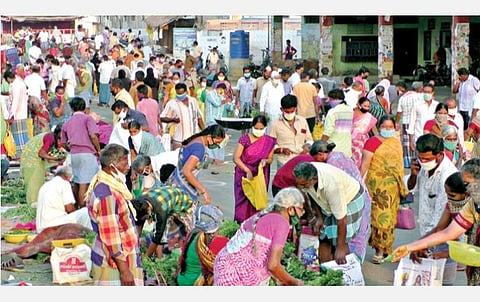 கோபி பேருந்து நிலையத்தில் செயல்படும் காய்கறிச் சந்தையில் சமூக இடை வெளியைப் பின்பற்றாமல் நெருக்கமாக நின்று காய்கறிகளை வாங்கும் பொதுமக்கள்.