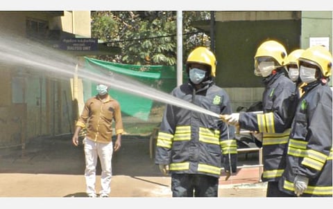 கோவை மேட்டுப்பாளையத்தில் கிருமிநாசினி மருந்து தெளிக்கும் பணியில் ஈடுபட்டுள்ள தீயணைப்புத் துறையினர்.