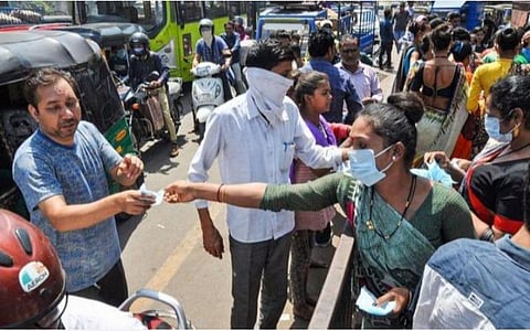 முகக்கவசங்களை சாலைகளில் வேகவேகமாக வாங்கிச்செல்லும் மக்கள்.