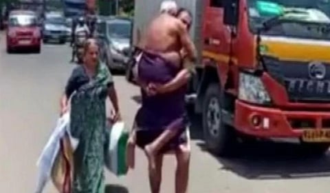 தனது தந்தையை தோளில் சுமந்து கொண்டு சாலையில் நடந்த மகன் : படம் | ஏஎன்ஐ.