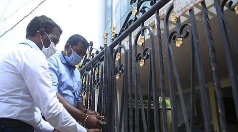 தங்கும் விடுதிக்கு சீல் வைக்கும் அதிகாரிகள்