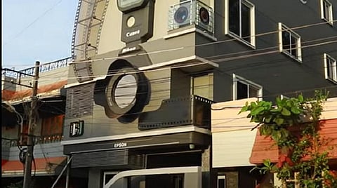 கேமிரா வடிவ வீட்டின் முன்னால் புகைப்பட கலைஞர் ரவி ஹொங்கல் தன் குடும்பத்தினருடன்