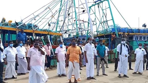 காரைக்கால் மீன்பிடித் துறைமுகத்தில் விசைப்படகுகளில் கருப்புக் கொடியேற்றி ஆர்ப்பாட்டத்தில் ஈடுபட்ட மீனவர்கள்.