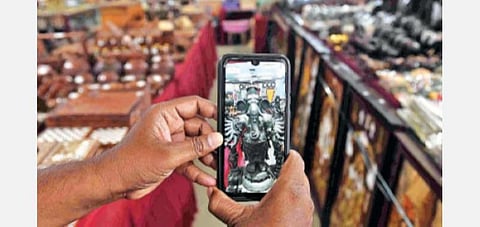 கோவை பூம்புகார் விற்பனை மையத்தில், செல்போன் செயலி மூலம் பொருட்களை காணும்முறை குறித்து விளக்கப்படுகிறது. படம்: ஜெ.மனோகரன்