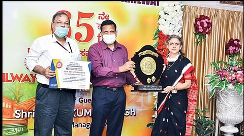 தென்மேற்கு ரயில்வே கோட்டத்தின் பொது மேலாளர் ஏ.கே.சிங் வழங்கிய விருதை மைசூரு மண்டல மேலாளர் அபர்ணா கர்க் பெற்றுகொண்டார்.