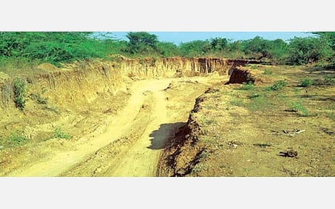 மண் தோண்டப்பட்டு பள்ளமாக காட்சியளிக்கும் கவுசிகா நதி.
