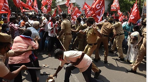 போலீஸார் தடியடியால் சிதறிக் கிடக்கும் பொருட்களை எடுக்க முற்படும் தொழிலாளர்கள். | படங்கள்- எம்.சாம்ராஜ்