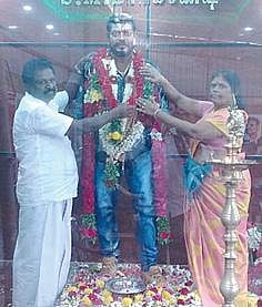 மகன் மாரிகணேஷ் மெழுகுச் சிலையுடன் பெற்றோர்.
