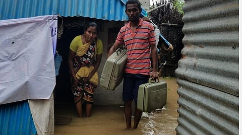 பூரணாங்குப்பம் அன்பு நகரில் வீட்டில் தண்ணீர் புகுந்ததால் பெட்டியில் துணிகளுடன் வெளியேறும் தம்பதி.