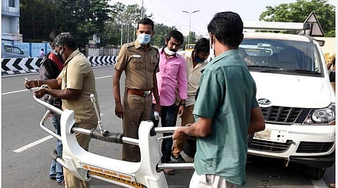 கோவை அவிநாசி சாலையில் எல்.ஐ.சி சிக்னல் அருகே வாடகை காரின் பம்பரை அகற்றிய போக்குவரத்துத் துறையினர் | படம்:ஜெ.மனோகரன்.