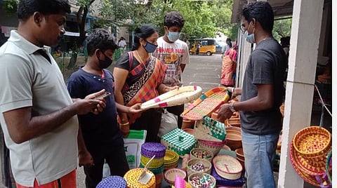 கிராஸ்கட் ரோடு மாநகராட்சிப் பள்ளியில் நடைபெற்ற நம்ம ஊரு சந்தையில், பனை ஓலையால் தயாரிக்கப்பட்ட பொருட்களை வாங்கிய பொதுமக்கள். | படம்: த.சத்தியசீலன்.
