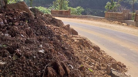 குரங்கணி மலைப்பாதையின் சாலையில் சரிந்து விழுந்து கிடக்கும் பாறை