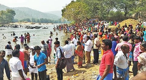ஒகேனக்கல் முதலைப் பண்ணை எதிரேயுள்ள காவிரியாற்றில் குளிக்க திரண்ட சுற்றுலா பயணிகள்.