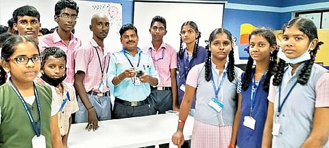 மிகச்சிறிய செயற்கைக்கோள் தயாரிப்பில் ஈடுபட்ட திருமால்பூர் அரசு மேல்நிலை பள்ளி மாணவர்கள் குழுவினர். அடுத்த படம்: மாணவர்கள் தயாரித்த 50 கிராமுக்கும் எடை குறைவான செயற்கைக்கோள்.