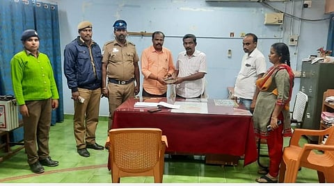 ரூ.2.29 லட்சத்தை நிலையான கண்காணிப்புக்குழு 5-ன் அதிகாரி முருகன், அரவக்குறிச்சி வட்டாட்சியர் பன்னீர்செல்வத்திடம் ஒப்படைக்கிறார்.