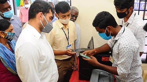 காரைக்காலில் மாதிரி வாக்குச் சாவடியைத் திறந்து வைத்து, அதில் மின்னணு வாக்காளர் அட்டையைப் பதிவிறக்கம் செய்யும் முறை குறித்து வாக்காளர் அறிந்து கொள்வதைப் பார்வையிட்ட மாவட்ட ஆட்சியர் அர்ஜூன் சர்மா.
