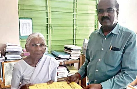 கமலாத்தாள் பெயரில் நிலம் பதிவு செய்த ஆவணத்தை அவரிடம் வழங்கிய மஹிந்திரா குழும ஊழியர்.