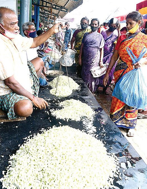 மாட்டுத்தாவணி சந்தையில் விற்பனைக்கு குவிக்கப்பட்டுள்ள மதுரை மல்லிகை. படம்: ஜி.மூர்த்தி