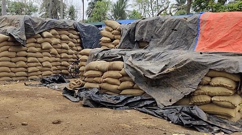 மயிலாடுதுறை திறந்தவெளி சேமிப்புக் கிடங்கில் அரைகுறையாகத் தார்ப்பாய் போட்டு மூடி வைக்கப்பட்டிருக்கும் நெல் மூட்டைகள்.