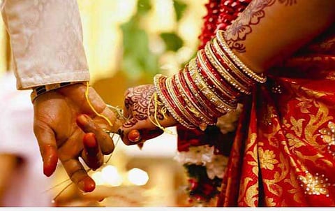திருமணம் முடிந்த புதுமணத் தம்பதி; சாலையில் நின்று கரோனா விழிப்புணர்வு