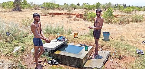 பரமத்தி அருகே சாலையோரத்தில் லாரியை நிறுத்தி கேட்வால்வில் கசியும் தண்ணீரில் ஆனந்த குளியல் போடும் லாரி ஓட்டுநர்கள். படம்: கி. பார்த்திபன்