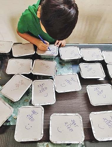 ஊரடங்கின் போது ஏழைகளுக்கு வழங்குவதற்கான உணவு பார்சல்களில் அன்பை பொழிந்த சிறுவன்: சமூக வலைதளங்களில் குவியும் பாராட்டு