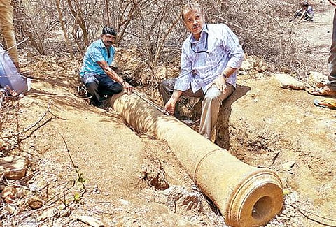 வேலூர் மலை கோட்டையில் கண்டெடுக்கப்பட்ட பீரங்கியை அருங்காட்சியக காப்பாட்சியர் சரவணன் பார்வையிட்டு ஆய்வு செய்தார். படம்: வி.எம்.மணிநாதன்.