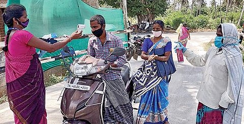 பட்டுக்கோட்டை அருகே உள்ள பள்ளிகொண்டானில் அமைக்கப்பட்டுள்ள சோத னைச் சாவடியில் உடல்நிலை குறித்து பரிசோதனை செய்யும் பணியாளர்கள்.