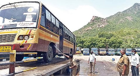 திருவண்ணாமலையில் உள்ள பணிமனையில் அரசு பேருந்தை சுத்தம் செய்யும் பணியில் ஈடுபட்டுள்ள தொழிலாளர்கள்.