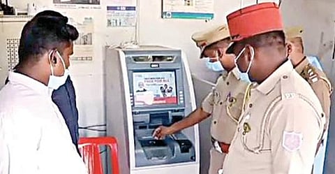 புதுச்சேரி அருகே கன்னியக்கோயிலில் கொள்ளை நடந்த எஸ்பிஐ வங்கி ஏடிஎம்மில் ஆய்வு செய்யும் போலீஸார்.