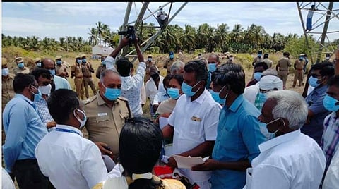 இழப்பீடு வழங்காமல் பணிகளைத் தொடரக் கூடாது: உயர் மின்கோபுரத்தில் ஏறி விவசாயிகள் போராட்டம்