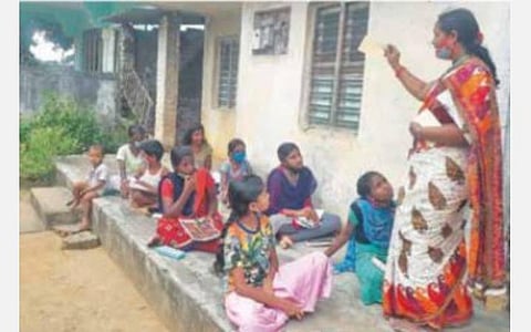 அஞ்சல் அட்டை மூலம் தொடர்பு கொள்வது குறித்து விளக்கும் ஆசிரியை மகாலட்சுமி.